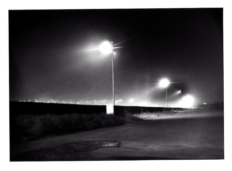 Massive flood lights illuminate the Tijuana River from the US side of the border to eliminate the cover of darkness from Mexicans attempting to cross into the United States, San Ysidro, California, USA..